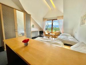 a bedroom with two beds and a table with a flower on it at Hotel Pension Linz in Bühl