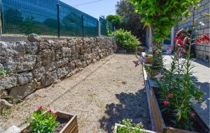 un giardino con fiori e un muro di pietra di Awesome Home In Petreto Bicchisano a Petreto-Bicchisano