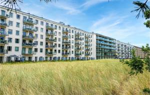 a large white apartment building with a field of grass at 2 Bedroom Stunning Apartment In Prora in Streu