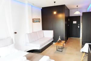 a living room with a white couch and a table at Afytos Lofts in Afitos