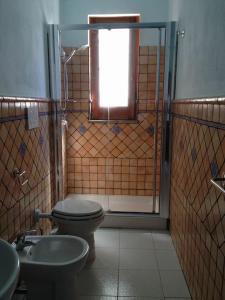 baño con aseo, ventana y lavamanos en Casa Masaria, en Lipari