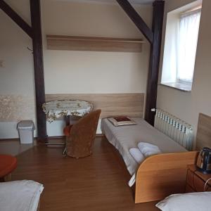 a room with two beds and a table in it at Turystyka Wiejska AGRO-DOM in Milanowska Wolka