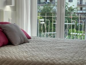 a bedroom with a bed with pink pillows and a window at Pianohome Sorrento in Piano di Sorrento