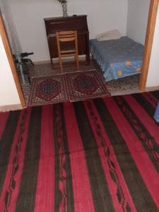 a room with a table and a chair and a rug at EFTHYMIOS Φθηνη και ησυχη διαμονη in Grammatikoú