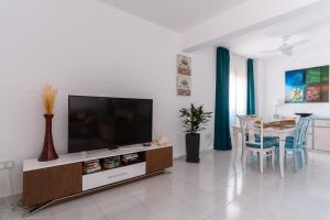 Una sala de estar con un televisor de pantalla plana y una mesa. en Diana's Heights by Prestige Bookings, en Peyia