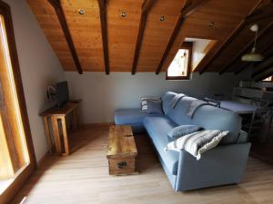 a living room with a blue couch and a table at La Borda de Jaime in Piedrafita de Jaca