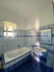 a blue and white bathroom with a sink and a tub at Shuko Village House in Sarandë +23 photos