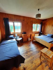 1 dormitorio con 2 camas y suelo de madera en Jaun-Ieviņas, en Rauna