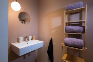y baño con lavabo blanco y toallas púrpuras. en B&B Villa Kriekenbeek, en Lent