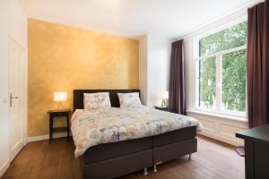 1 dormitorio con cama y ventana grande en B&B Villa Kriekenbeek, en Lent
