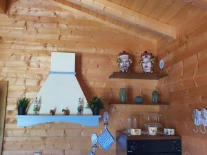uma cozinha com uma parede de madeira com uma luz e prateleiras em Depandance con Piscina e Jacuzzi em Fontane Bianche