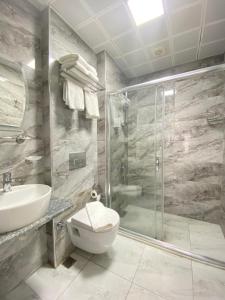 ein Bad mit einer Dusche, einem WC und einem Waschbecken in der Unterkunft ATİK HOTEL in Istanbul
