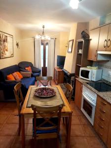 Una cocina y una sala de estar con una mesa y un sofá. en Torre Blanca, en Riópar Viejo