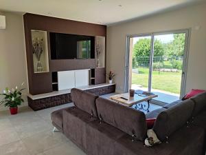 sala de estar con sofá y TV en La Cascatelle - Gîte entièrement climatisé en Savigny-en-Revermont