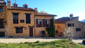 an old stone building with black shutters on it at Torre Blanca in Riópar Viejo