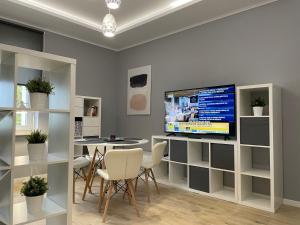 a living room with a television and a table and chairs at Apartament BERLIN in Białystok