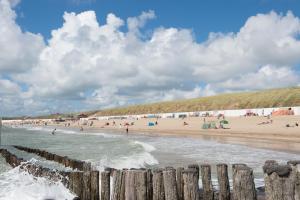 a beach with a bunch of people in the water at Charley's Home 2 personen in Westkapelle