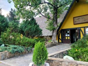 a yellow building with a tree in front of it at Magic Home in Slănic