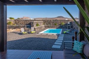 vistas a la piscina desde el patio de una casa en Villa Alejandra, en Lajares