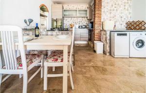 kuchnia ze stołem i krzesłami oraz pralką i suszarką w obiekcie 3 Bedroom Gorgeous Home In Estepona w mieście Estepona
