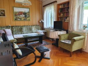 uma sala de estar com um sofá e cadeiras e uma televisão em Sovica em Bled