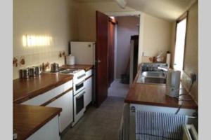 a kitchen with a sink and a refrigerator at Preston Villa, spacious ground floor apartment in Buckie