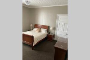 a bedroom with a bed and two night stands and a table at Preston Villa, spacious ground floor apartment in Buckie
