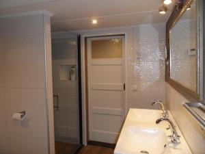 a bathroom with a sink and a mirror and a shower at B&B Manderscheid-Blick in Pantenburg