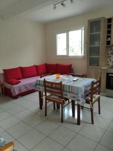 a living room with a table and a red couch at ASTERIA HOUSE in Kala Nera