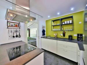 a kitchen with white cabinets and a yellow wall at Die HAMMERHÜTTE in Willingen