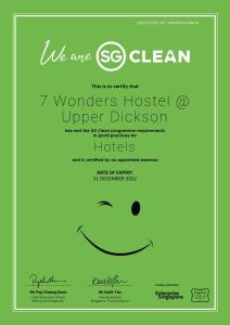 a green poster with a smiley face at 7 Wonders Hostel at Upper Dickson in Singapore