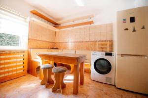 a kitchen with a table and a washing machine at Apartament Beatrice in Râşnov