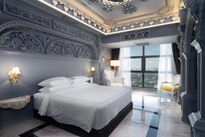 sypialnia z białym łóżkiem i niebieską ścianą w obiekcie Arte by Thomas Chan w Kuala Lumpur