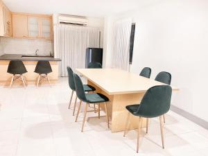 a kitchen with a wooden table and chairs at Grand Residence in Bangkok