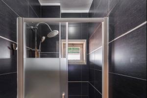 W łazience znajduje się prysznic ze szklanymi drzwiami. w obiekcie Silver Duque w Porto