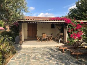 a patio with a table and chairs and flowers at Villa A Pineta in Porticcio