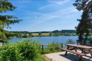 a wooden picnic table sitting next to a lake at Schwarzwaldmarie Ferienwohnung in Löffingen