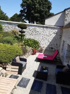 eine Terrasse mit Sofas und einem Brunnen im Garten in der Unterkunft Les Maharanis in Moisenay