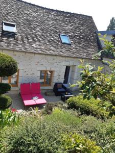 a pink couch in front of a house at Les Maharanis in Moisenay