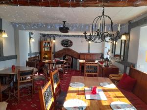 a dining room with tables and chairs and a chandelier at The Golden Lion Inn in Denbigh