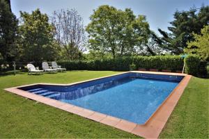 a swimming pool in a yard with two chairs at Cal Terri Rural in Perafita