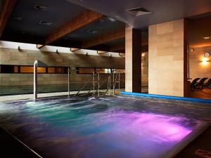 una piscina en una habitación con agua azul y púrpura en VacationClub – Marine Hotel Apartament 437, en Kołobrzeg