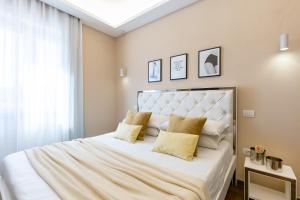sypialnia z dużym białym łóżkiem z żółtymi poduszkami w obiekcie Club 57 Imperial Rooms w Cagliari