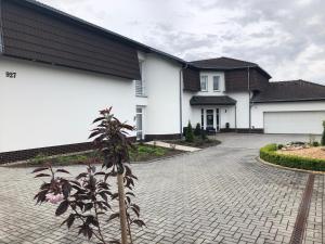 a white house with a brick driveway at Penzion Lomská Vyhlídka in Lom u Mostu