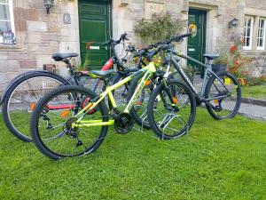 drei Fahrräder im Gras vor einem Haus geparkt in der Unterkunft Ford Village Bed & Breakfast in Ford