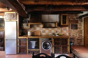 a kitchen with a refrigerator and a washing machine at El Salto del Agua in Orbaneja del Castillo +12 photos