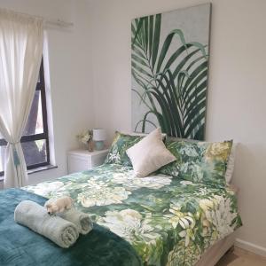 a bedroom with a bed with a stuffed animal on it at Waybury Cottage - a cozy home from home ! in Johannesburg