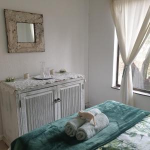 un dormitorio con una cama con un animal de peluche en Waybury Cottage - a cozy home from home !, en Johannesburgo