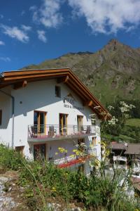 a white building with a mountain in the background at Piz Ot in Samnaun