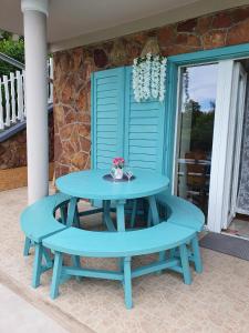 einem blauen Picknicktisch auf der Veranda eines Hauses in der Unterkunft Mama motel in Zánka